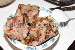 Обжаренные свиные ребрышки выложены на тарелку