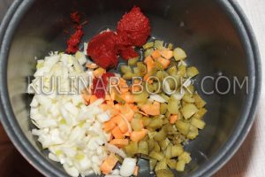 Огурцы, лук, морковь и томатная паста в чаше мультиварки