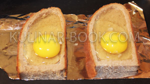 В вырезанные отверстия в хлебе вбиты яйца