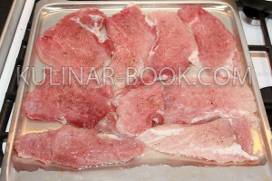 Свиное мясо выложено на противень с водой