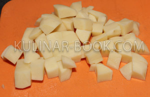 Картофель нарезан кубиками  на разделочной доске